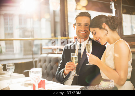 Bien-habillé couple drinking champagne in restaurant Banque D'Images