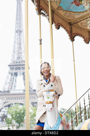 Woman riding carousel près de Eiffel Tower, Paris, France Banque D'Images