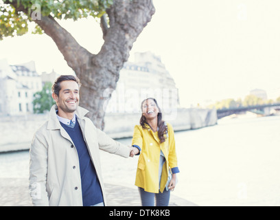 Couple holding hands le long de la rivière Seine, Paris, France Banque D'Images