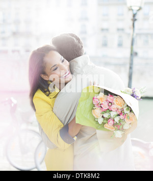 Couple avec bouquet de fleurs serrant le long de la rivière Seine, Paris, France Banque D'Images