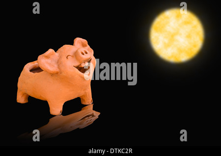 Statue cochon de rire sur la lumière de la pleine lune Banque D'Images