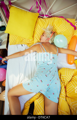 Woman sleeping on bed after party Banque D'Images