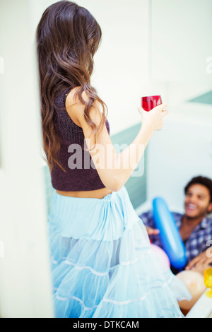 Femme parlant à ami en baignoire at party Banque D'Images