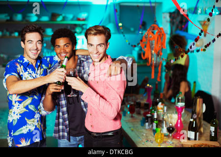 Les hommes toasting each other at party Banque D'Images