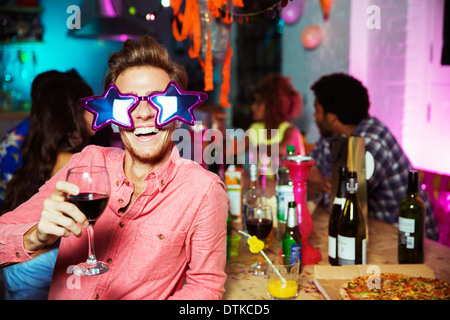Homme portant des lunettes surdimensionnées at party Banque D'Images