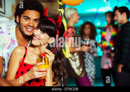 Man hugging girlfriend at party Banque D'Images