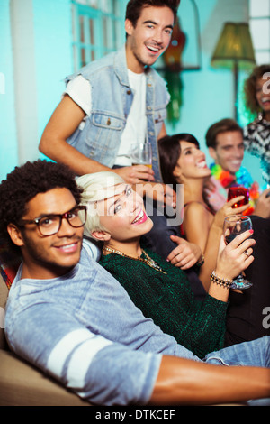 Les amis de boire on sofa at party Banque D'Images