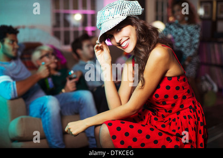 Femme assise dans la salle de séjour at party Banque D'Images