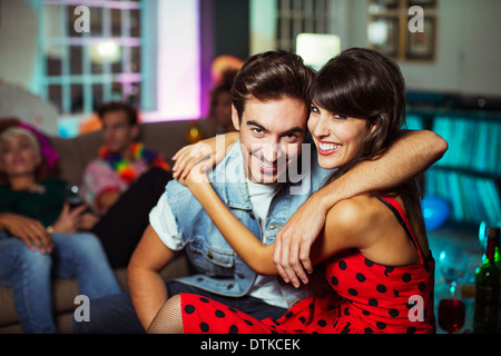 Couple hugging in living room at party Banque D'Images