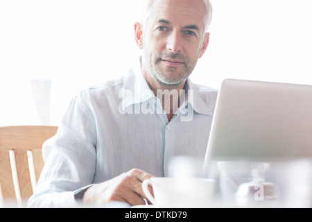 Businessman using laptop in cafe Banque D'Images