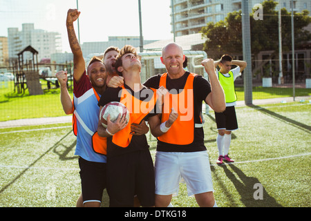 Joueurs de football cheering on field Banque D'Images