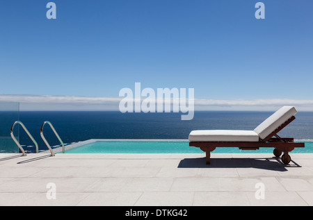 Piscine à débordement et lounge chair overlooking ocean Banque D'Images
