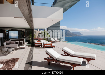 Patio moderne et une piscine à débordement donnant sur l'océan Banque D'Images