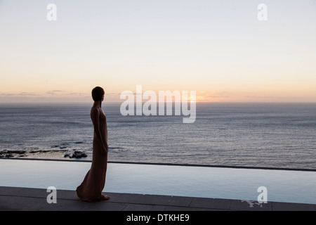 Woman looking at Ocean de patio Banque D'Images