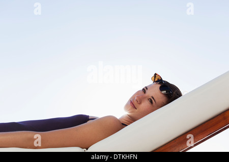 Woman laying on lounge chair outdoors Banque D'Images