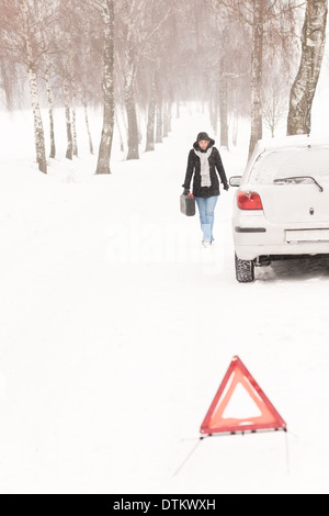 Woman walking with gas can car snow Banque D'Images