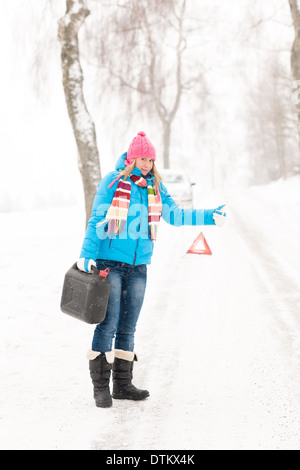 Femme de l'auto-stop sur la neige peut gaz Banque D'Images