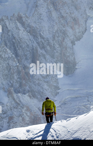 Traversée d'un grimpeur solitaire au-dessous de la crête du Mont Blanc, haut au-dessus de la vallée de Chamonix dans les Alpes françaises. Banque D'Images