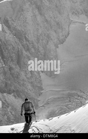 Traversée d'un grimpeur solitaire au-dessous de la crête du Mont Blanc, haut au-dessus de la vallée de Chamonix dans les Alpes françaises. Banque D'Images