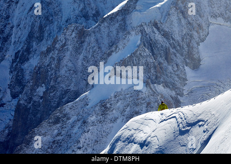 Traversée d'un grimpeur solitaire au-dessous de la crête du Mont Blanc, haut au-dessus de la vallée de Chamonix dans les Alpes françaises. Banque D'Images