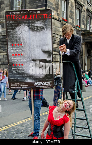 La promotion des artistes de théâtre Livewire "La lettre écarlate" sur la rue principale à l'Edinbugh 2013 Fringe Festival. Banque D'Images