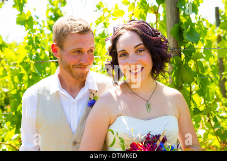 Mariée et le marié le partage d'un moment et qui pose pour la caméra dans ce portrait des deux personnes dans un vignoble dans la cave de leur Banque D'Images