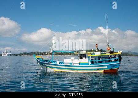 Brésil, Rio de Janeiro, Buzios. Bateau de pêche locale au large de la côte de Buzios. Océanie croisière dans la distance, la régate. Banque D'Images