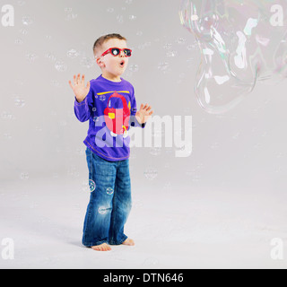 Petit enfant jouant avec des bulles de savon Banque D'Images