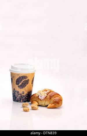 Café en gobelet jetable et un croissant aux amandes et flocons brown sugar cubes Banque D'Images