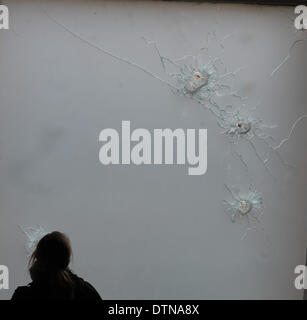 Kiev, Ukraine. Feb 21, 2014. Un journaliste regarde trous de balle sur la fenêtre d'un hôtel près de la place de l'Indépendance à Kiev, Ukraine, le 21 février 2014. Le président ukrainien et des dirigeants de l'opposition ont signé un accord vendredi pour mettre fin à la crise politique, qui a fait des dizaines de morts et des centaines de blessés. Credit : Dai Tianfang/Xinhua/Alamy Live News Banque D'Images