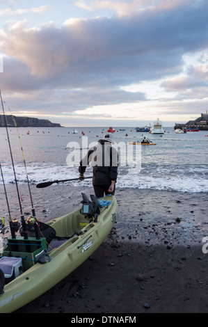 Deux hommes avec des kayaks de pêche de sortir tôt le matin à partir de la plage de San Juan, Tenerife, Canaries, Espagne. Banque D'Images