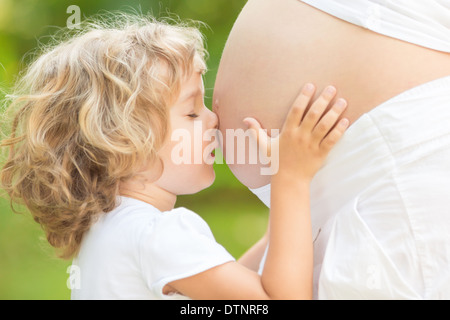 Embrassant l'enfant ventre de femme enceinte Banque D'Images