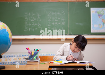 Lycéenne en s'appuyant sur un livre de coloriage Banque D'Images