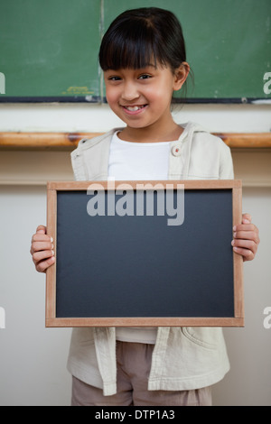 Portrait d'une jeune fille tenant une ardoise scolaire Banque D'Images
