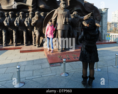 Prendre des photos en face de la sculpture héroïque au début de l'amitié sino-pont. Dandong, province de Liaoning, Chine Banque D'Images