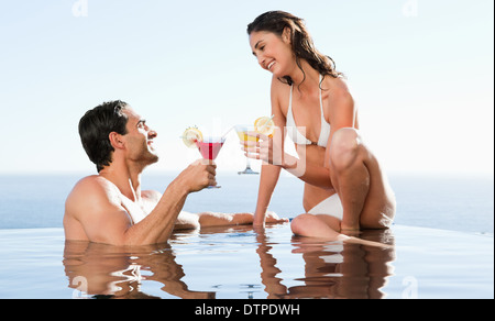 Couple having cocktails dans la piscine Banque D'Images