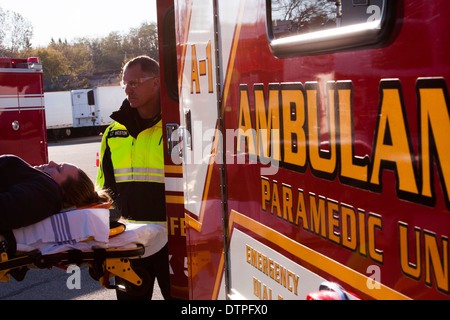 EMT un chargement d'un patient à l'arrière d'une Ambulance Banque D'Images