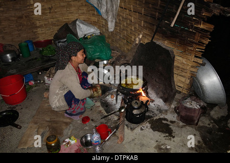 Pommes de terre de cuisson sur un feu ouvert dans une maison d'hôtes dans la région du Manaslu au Népal. Banque D'Images