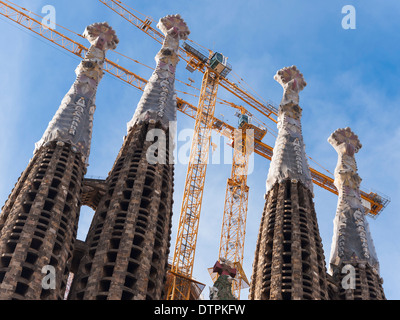 Grues de construction à la façade de la nativité "tours" d'Antonio Gaudi's cathédrale "Sagrada Familia" à Barcelone, Espagne. Banque D'Images