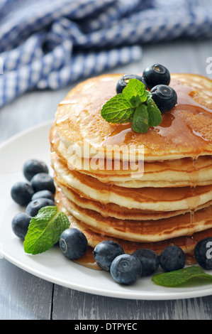 Des crêpes avec les baies fraîches, menthe et sirop d'érable sur plaque blanche libre Banque D'Images