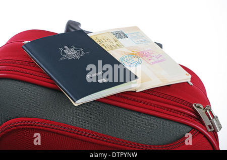 Les passeports australiens assis sur une valise de voyage rouge Banque D'Images