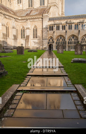 Dans la réflexion de pavage mouillé Wells Cathedral, Somerset, England, UK Banque D'Images