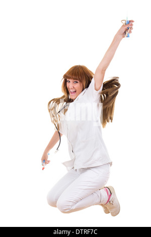 Smiling happy nurse en uniforme holding syringe and stethoscope jumping Banque D'Images