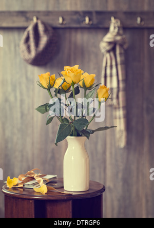 Afficher de roses jaunes sur table couloir avec des lettres attachées avec ruban Banque D'Images