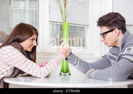 Beau jeune couple Arm wrestling sur la table Banque D'Images