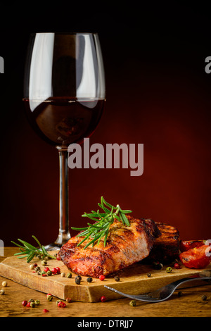 Nature morte avec pavé de boeuf, le romarin et le verre de vin rouge Banque D'Images