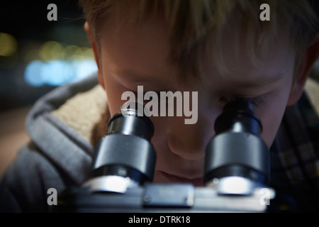 Portrait d'enfant Boy looking through microscope dans laboratoire d'école Banque D'Images