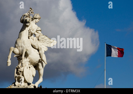 Equestrian statue en pierre avec le drapeau Français en arrière-plan à Paris France Banque D'Images