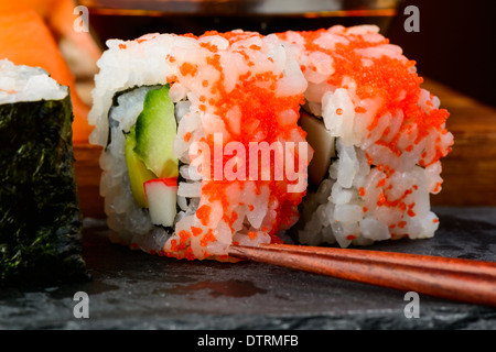 Closeup détail de california rolls sushi uramaki et baguettes Banque D'Images