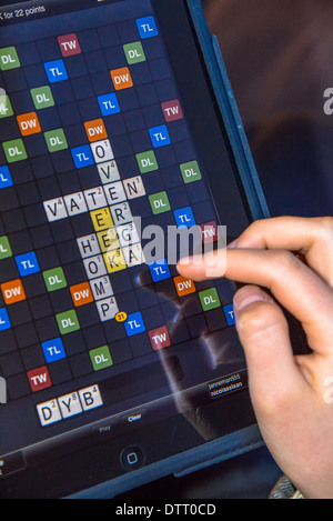 La main avec ipad jouer wordgame Banque D'Images